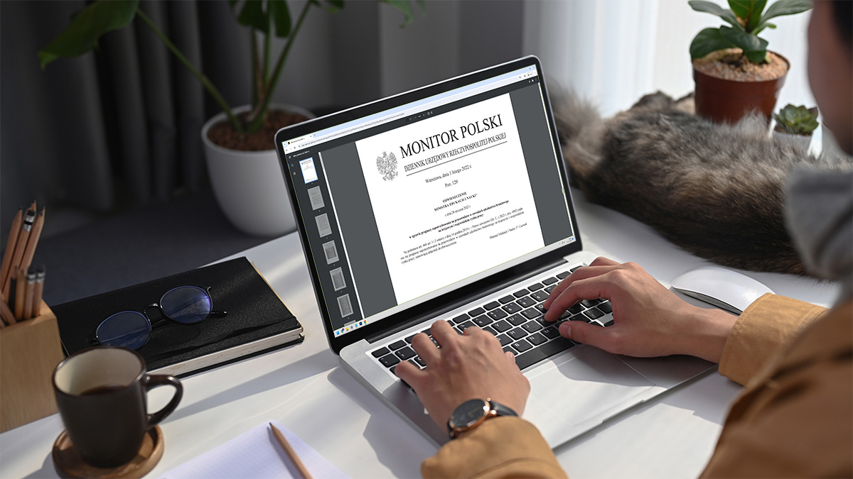 Kobieta patrzy na laptopa a na nim podgląd dokumentu.